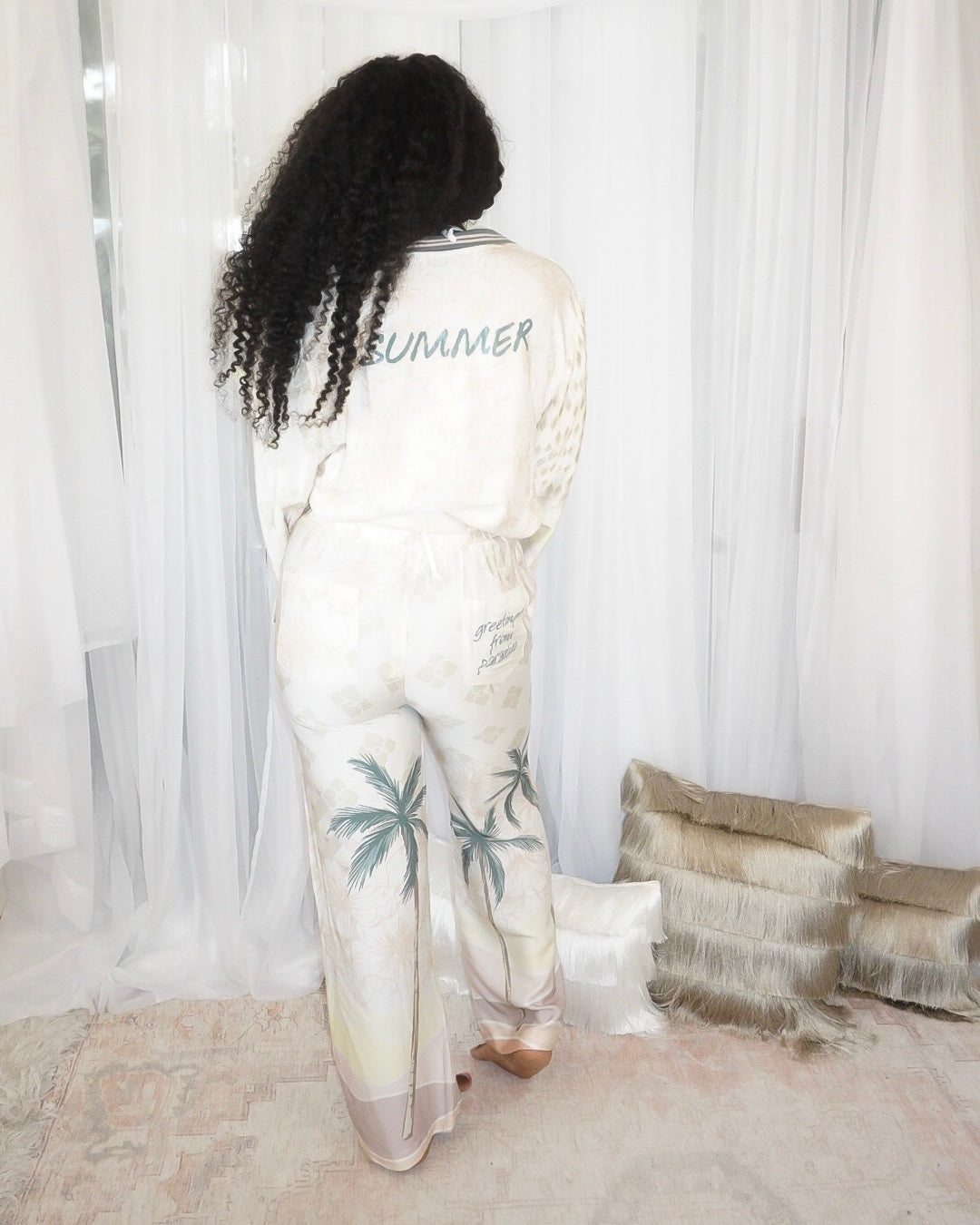 Back view of Summer Forever two piece resort pant set showing 'Summer'  text on the top and text on the back right pocket which reads 'Greetings from Paradise'.