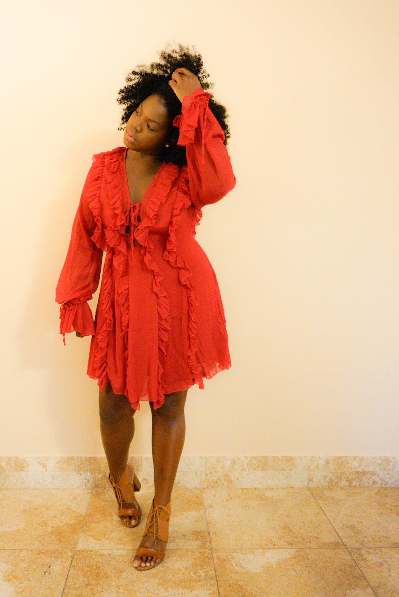 Woman wearing a romantic date night dress called the Veronica chiffon ruffle dress with long sleeves with ruffled wrist and flowy sleeves.